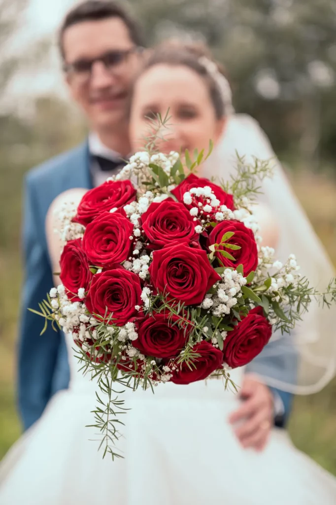 Détail sur le bouquet de la mariée avec les mariés en fond